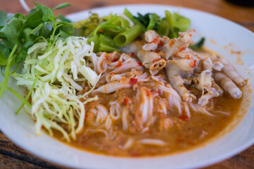 Thai rice noodle with chicken feet curry and vegetable on white dish