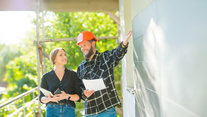 architect customer and builder worker at a construction site inspect plan check