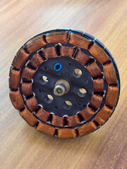 Ceiling fan winding stator structure, a brown and black object with a black center and a blue hole