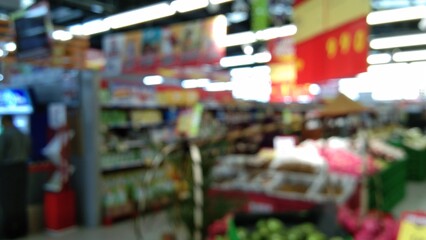 blurry photo of a white-floored supermarket with shelves selling goods in the background