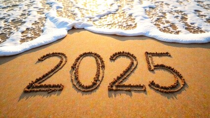 A sandy beach with the year 2025 written in the sand with with sea waves, top view. 2025 Happy new year, celebration, banner or greeting card