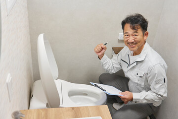トイレでガッツポーズする業者の男性