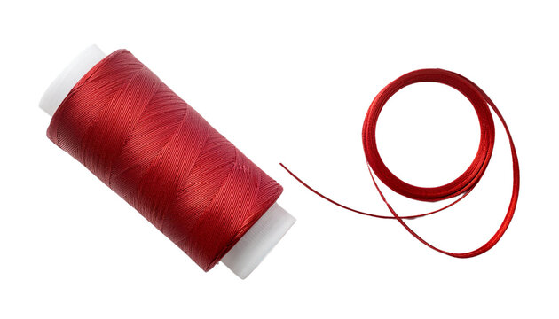 A vibrant red spool of thread with a length of red thread unraveled beside it.