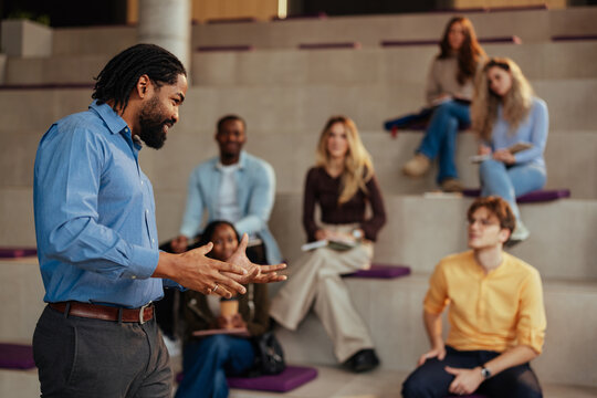 Professor giving a lecture to diverse group of students in modern university auditorium