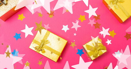 Fototapeta premium Image of stars falling over christmas presents