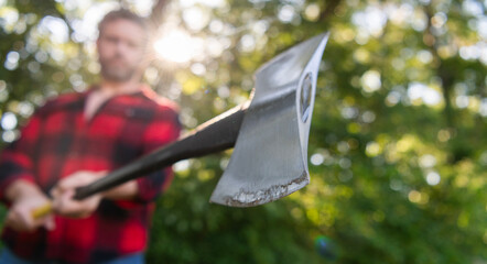 Axe in man chopping wood. Cutting wood. Sharp blade. Brutality and masculinity. Lumberjack with axe...