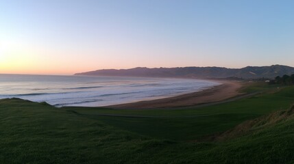Serene Coastal Landscape at Sunset Over Calm Ocean Waves and Green Hills
