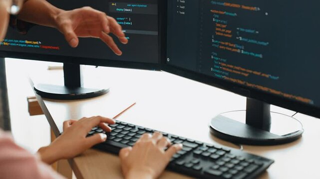 Slow motion back end or software developer manager supervising his team on new application program development on debugging and solving complex code algorithms on monitor. Burgeoning