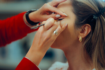 Professional Makeup Artist Making Perfect Eye wing with Liner. Woman wearing perfect eye makeup for...