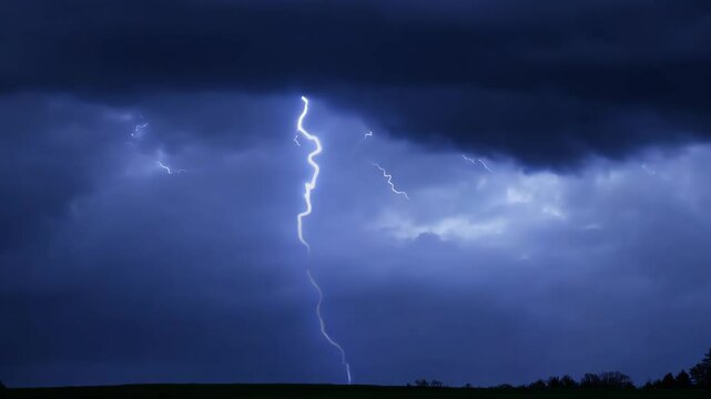 Dramatic lightning strikes during thunderstorm over dark clouds at night