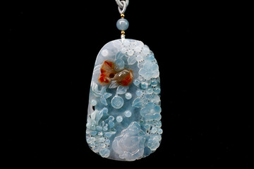 Jade pendant isolate on black background. Icy blue Burmese jadeite Jade carving with Happy Buddha,...