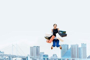 買い物袋を沢山持ってジャンプする女性（セール・爆買い）