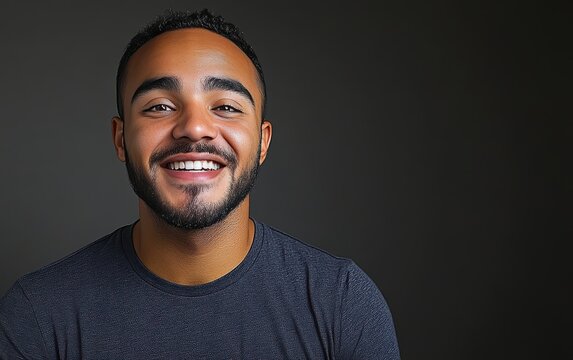 man with casual t-shirt is smiling at the camera, solid color background