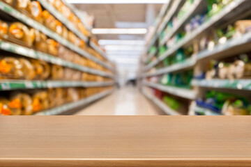 empty  wooden board empty table in front of blurred background. Perspective light wood over blur in supermarket. mock up used for display or montage your products. Wood floor and Supermarket blur.