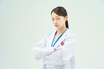 不満そうな表情の白衣の女性