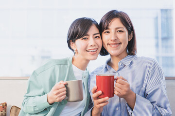 カップを手にする2人の女性（女性同士のパートナーのイメージ）