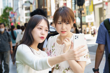 街中で自撮りする2人の女性