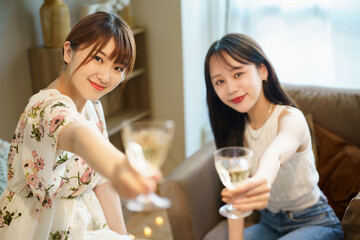 グラスを手に談笑する女性2人 © TAGSTOCK2