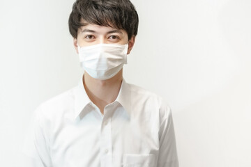白いシャツとマスクをつけた若い男性 © TAGSTOCK2