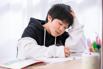 勉強で頭を抱える男の子