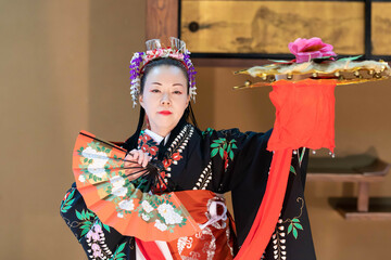 着物姿で扇子を持って日本舞踊を踊る若い日本人女性