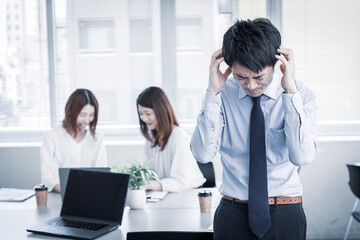 オフィスで頭を抱える男性