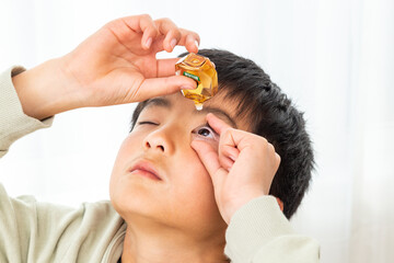 目薬をさす男の子