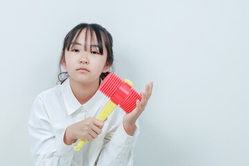 右手にハンマーを持ったカメラ目線の女の子