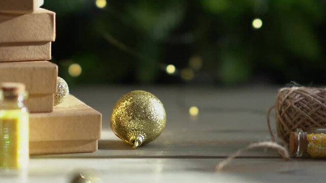 Holiday decor. Packing holiday gifts. Gift boxes, silver bow and Christmas gold balls against the backdrop of the Christmas tree and golden bokeh