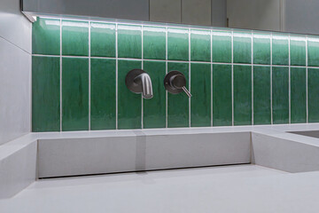 The bathroom with green tiles resembles a Starbucks bathroom interior