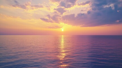 Obraz premium Sunset over calm ocean with dramatic clouds