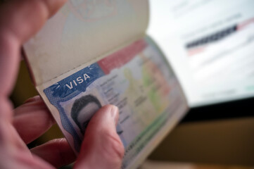 Unknown caucasian person holding passport with visa issued for United States of America