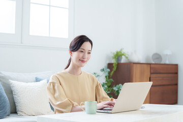 家でパソコンを使って仕事する女性