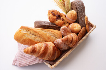 Sweet baked goods and croissants in the basket with bread and baguette captured from above