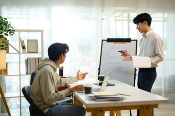 Tutor explaining grammar rules on a whiteboard while student listens and asks questions