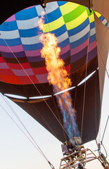 Obraz premium A hot air balloon with a red and orange striped body is floating in the sky