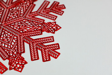 A red napkin in the form of a snowflake lies on a white background in close-up with space for text. High quality photo