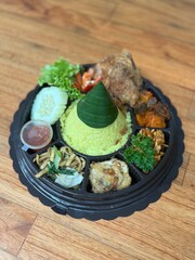 Yellow rice with banana leave cone on top with fried chicken 