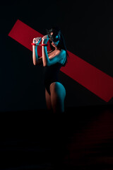 Sensual Woman in Cat Mask With Handcuffs Poses Against a Neon Backdrop Embracing the BDSM Aesthetic...