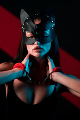 Portrait of a Sexy Woman in a Cat Mask and Handcuffs Against a Vibrant Neon Background Showcasing a Bold BDSM Aesthetic