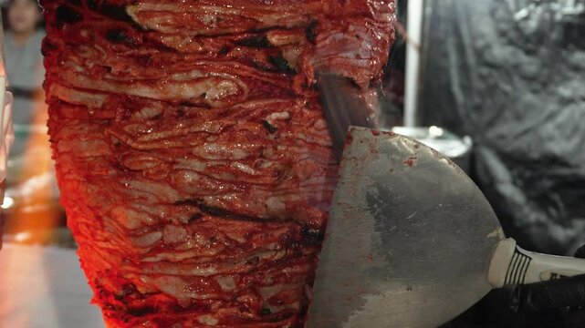 Mexican street food cutting up al pastor