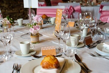 A beautifully set table featuring an elegant pink floral centerpiece, shimmering gold accents, and exquisite fine china, creating a warm and inviting atmosphere for gatherings and celebrations.
