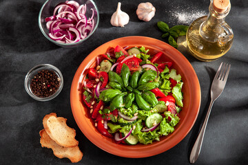 Fresh summer salad with tomatoes, cucumbers, onions, basil and pine nuts. A plate of salad on a...