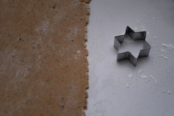 Rolled out spiced cookie dough with a star shaped cutter on a flour dusted surface