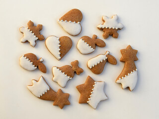 Decorated gingerbread cookies of various shapes on a white background. Christmas baking