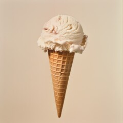 A single scoop of creamy vanilla ice cream with swirls of red sits atop a crispy waffle cone against a soft beige background.
