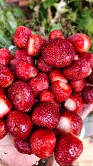 Many fresh whole strawberries in a glass bowl