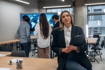 Front view of woman. Group of office workers are indoors together