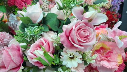 Background wall with artificial flowers of various colors.