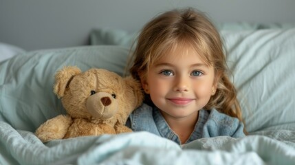 A young girl smiles while cuddling a teddy bear in a cozy bed.